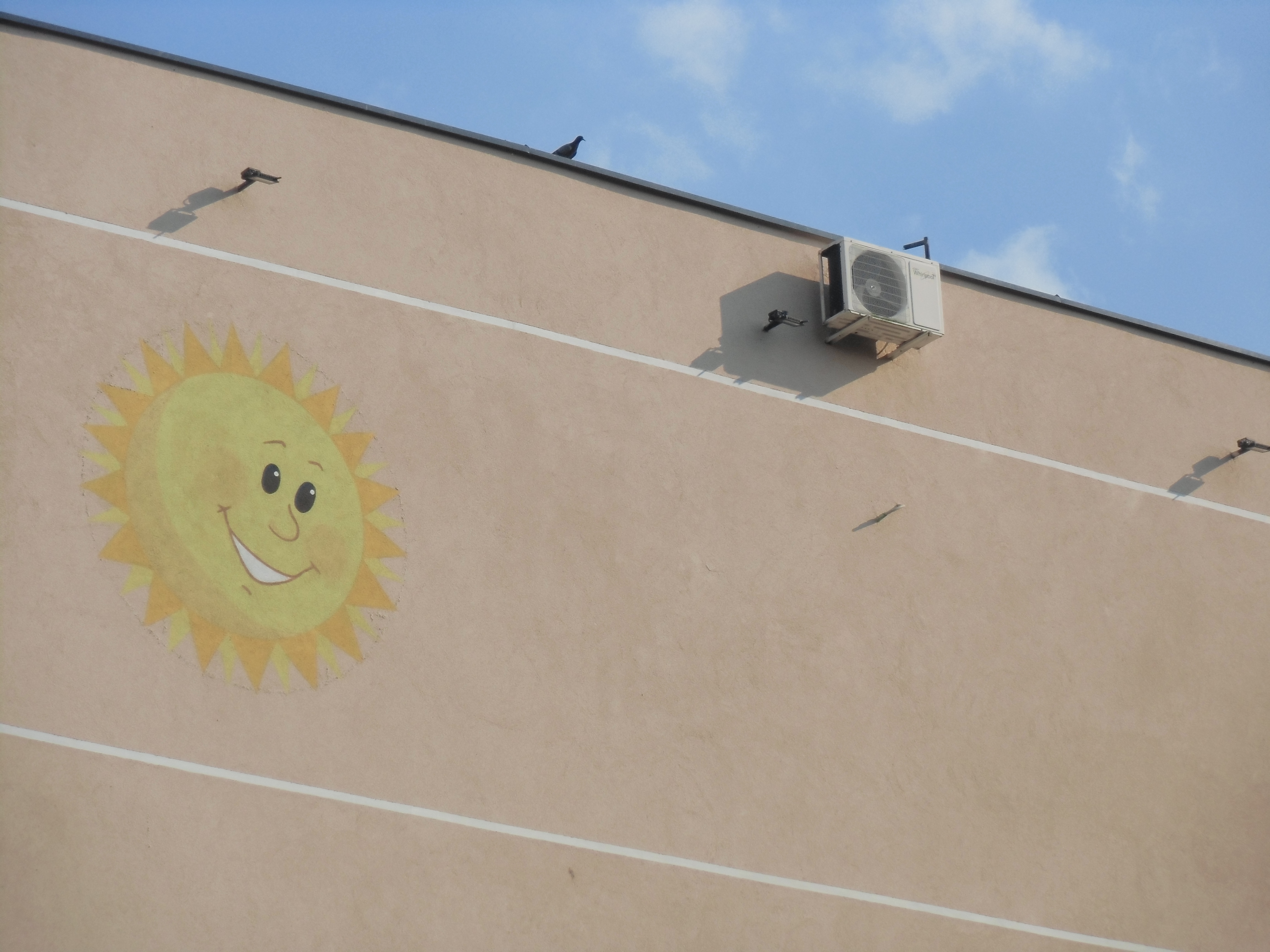 picture of a wall with a painted sun on it